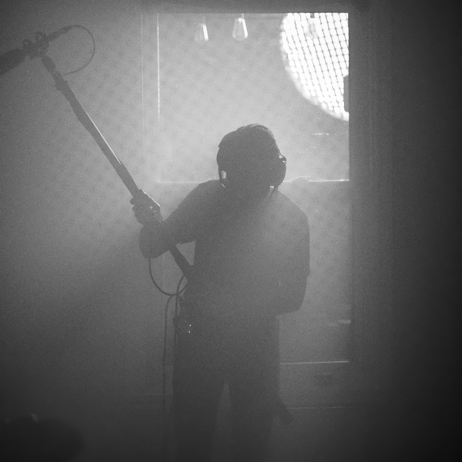 Boom operator recording sound in atmospheric haze